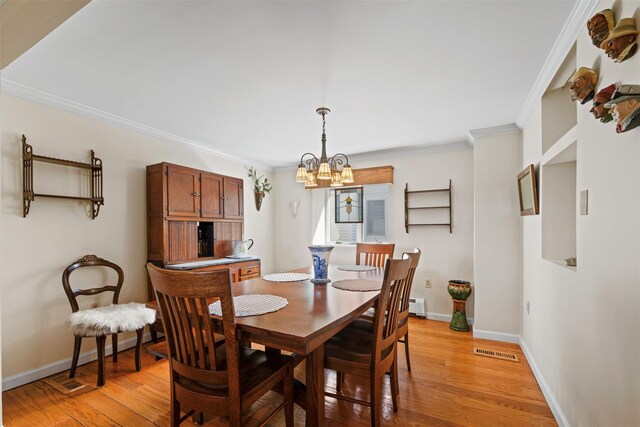 dining space featuring a notable chandelier, visible vents, baseboards, and light wood-style floors