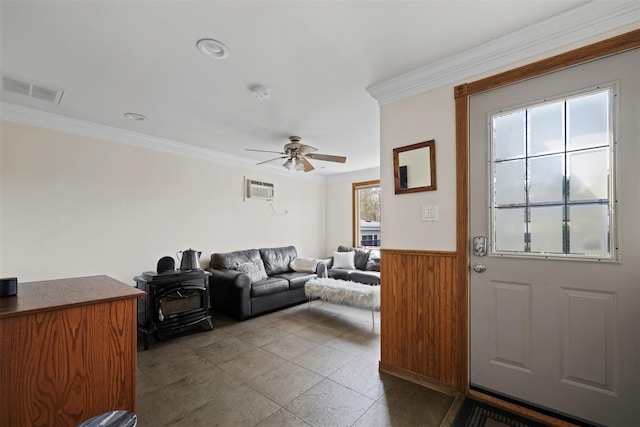 living room with visible vents, a ceiling fan, a wall unit AC, and crown molding