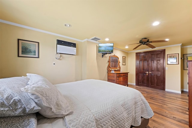bedroom with crown molding, visible vents, baseboards, recessed lighting, and a wall mounted AC