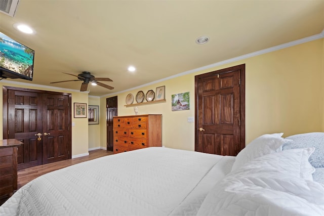bedroom featuring recessed lighting, visible vents, baseboards, ornamental molding, and wood finished floors