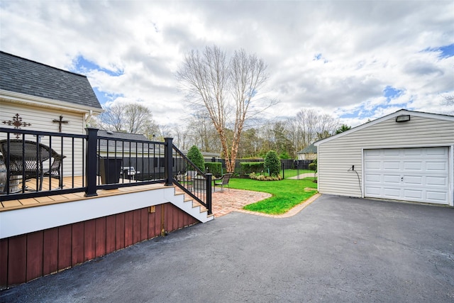 view of patio with an outdoor structure, fence, aphalt driveway, a garage, and stairs