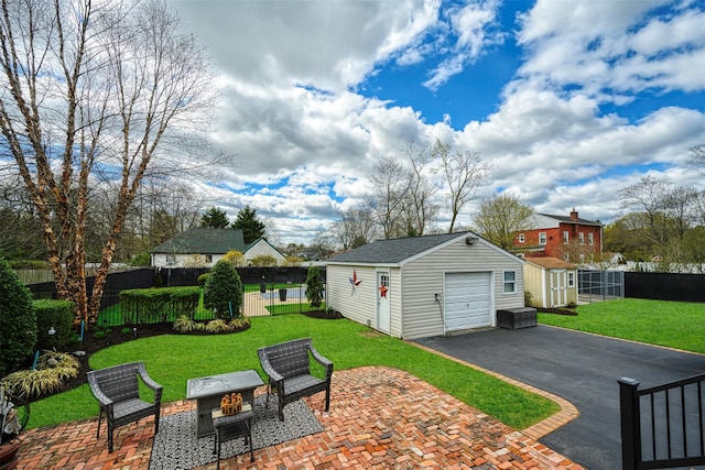 exterior space featuring driveway, an outdoor structure, fence, and a garage