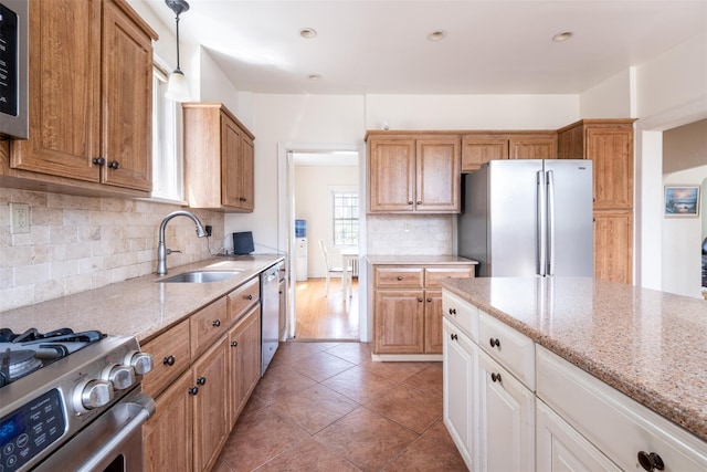 1065 Washington Ave, Pelham, NY 10803 - kitchen featuring backsplash, a sink, light stone counters, and stainless steel appliances