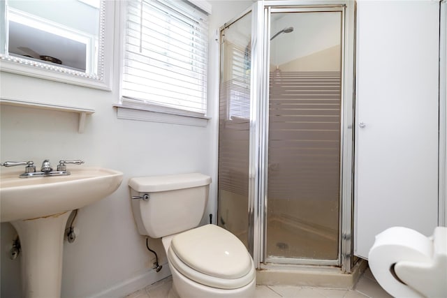 full bath featuring a shower stall, toilet, tile patterned floors, and baseboards