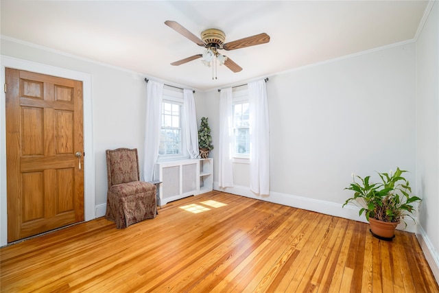 unfurnished room featuring radiator heating unit, a ceiling fan, crown molding, baseboards, and light wood-style flooring