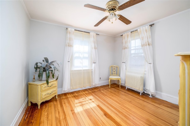 sitting room with radiator heating unit, plenty of natural light, a ceiling fan, and hardwood / wood-style floors