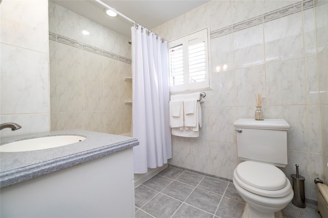 bathroom featuring tile patterned floors, toilet, vanity, tile walls, and a shower with shower curtain