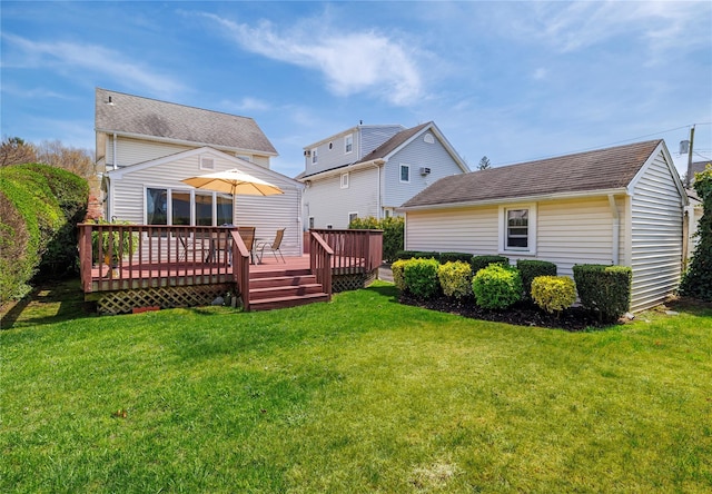 rear view of house featuring a lawn and a wooden deck
