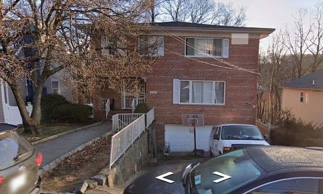 view of front facade with driveway, an attached garage, and brick siding