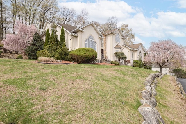 view of front facade with a front lawn and stucco siding