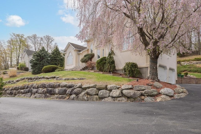 view of side of property with an attached garage and driveway