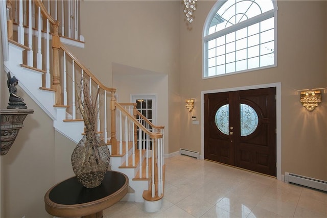 foyer with stairway, baseboards, a high ceiling, and baseboard heating