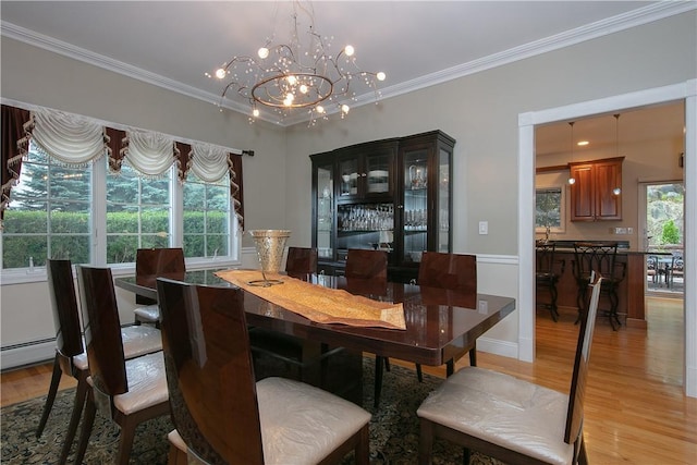 dining space with ornamental molding, light wood finished floors, a notable chandelier, and baseboard heating
