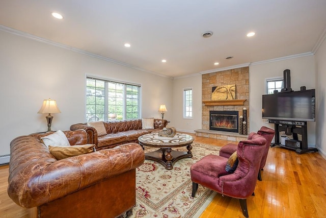 living room with crown molding, recessed lighting, a fireplace, and light wood-type flooring