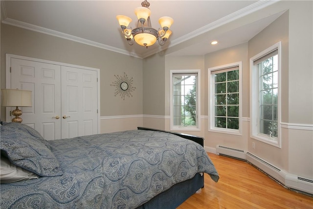 bedroom featuring a chandelier, recessed lighting, wood finished floors, ornamental molding, and a closet