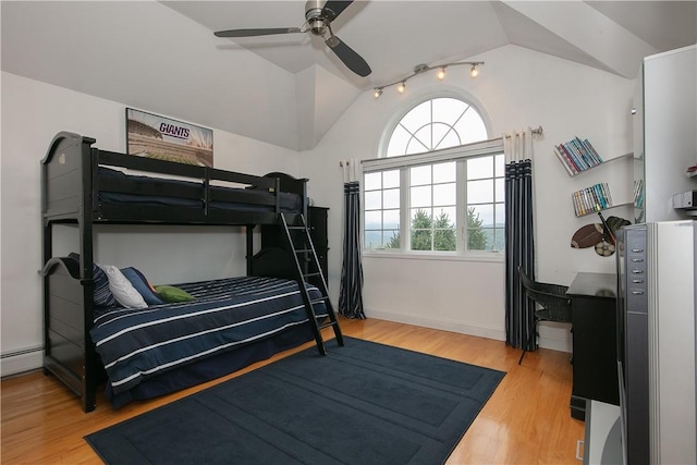 bedroom with vaulted ceiling, multiple windows, and wood finished floors