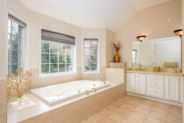 full bathroom featuring double vanity, a bath, tile patterned flooring, vaulted ceiling, and a sink