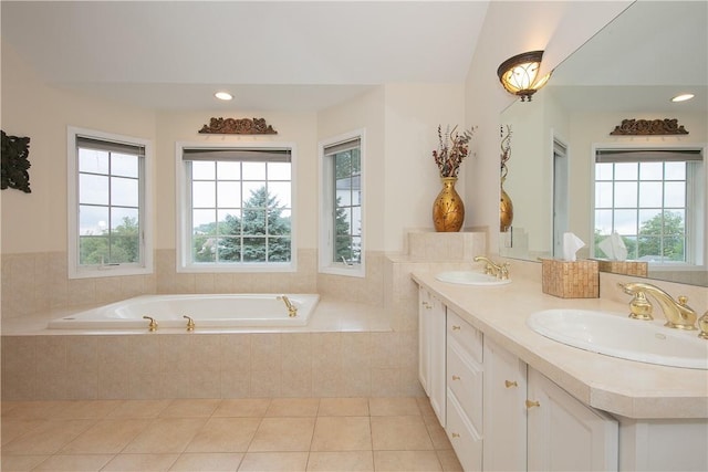 full bath featuring a sink, tile patterned floors, double vanity, and a bath