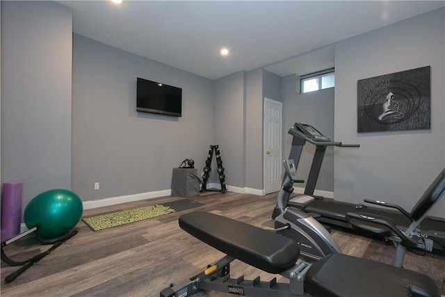 exercise area with baseboards and wood finished floors
