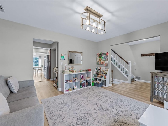 54 Hidden Ridge Dr, Syosset, NY 11791 - living room featuring stairs, wood finished floors, visible vents, and baseboards