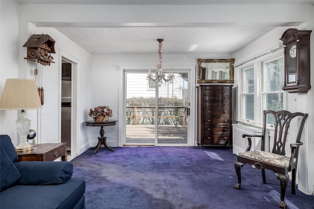 sitting room featuring an inviting chandelier and dark carpet