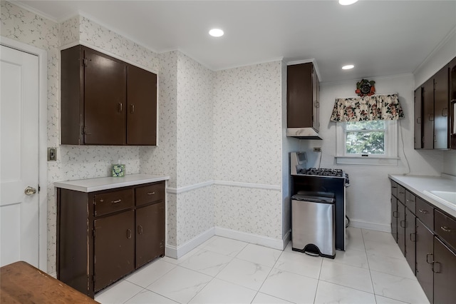 kitchen with light countertops, wallpapered walls, and ornamental molding