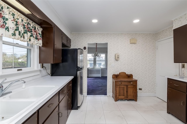 kitchen with light countertops, light tile patterned flooring, plenty of natural light, and ornamental molding