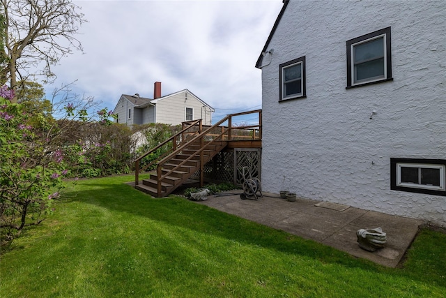 view of yard featuring stairs, a deck, and a patio