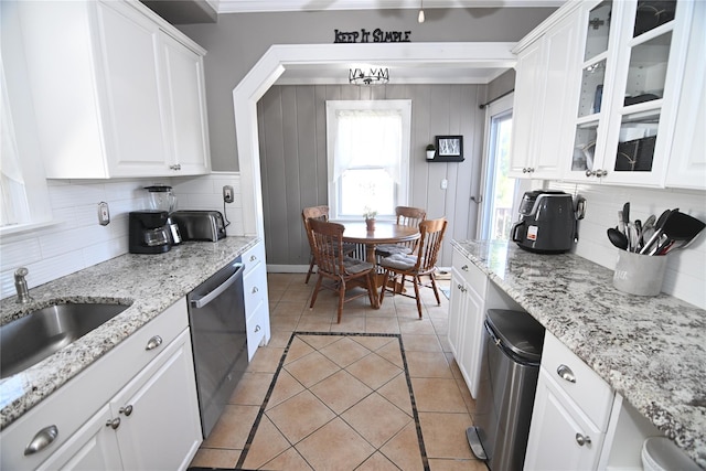 kitchen featuring tasteful backsplash, a sink, glass insert cabinets, dishwasher, and white cabinetry