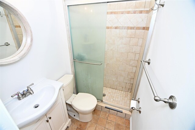 full bathroom featuring a shower stall, toilet, and vanity