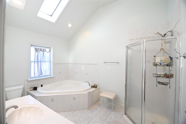 bathroom featuring a bath, vaulted ceiling with skylight, a sink, and a stall shower