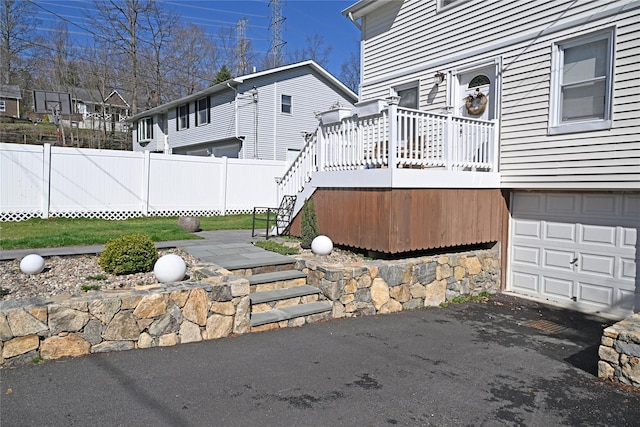 exterior space featuring fence, driveway, stairs, and a garage