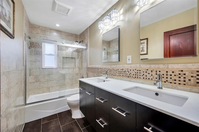 full bath featuring toilet, tile patterned flooring, a sink, and tile walls