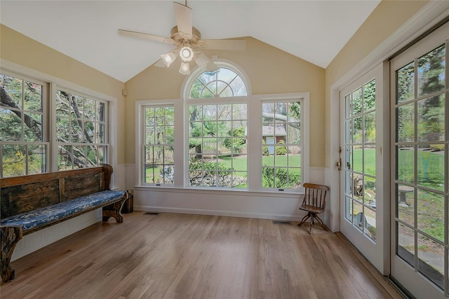 sunroom featuring visible vents, wood finished floors, and lofted ceiling