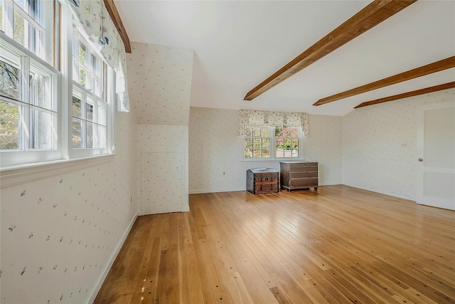 unfurnished living room featuring wallpapered walls and wood-type flooring