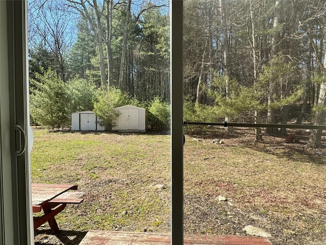 view of yard with fence, an outbuilding, and a shed