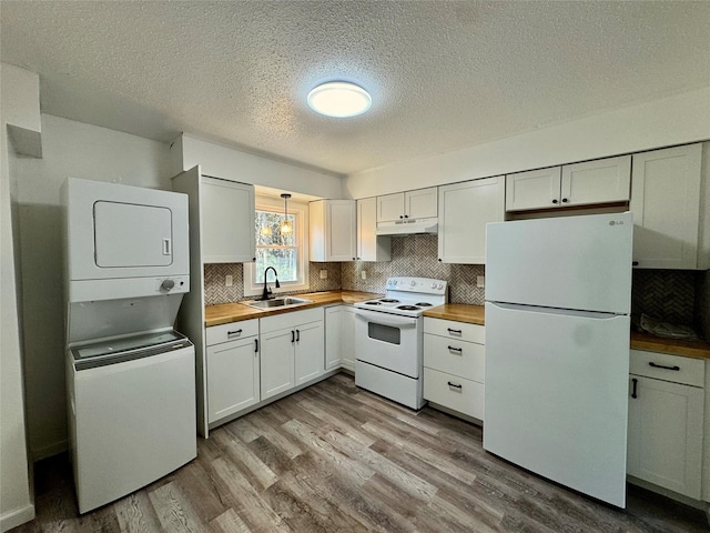 kitchen with butcher block countertops, under cabinet range hood, a sink, and white appliances