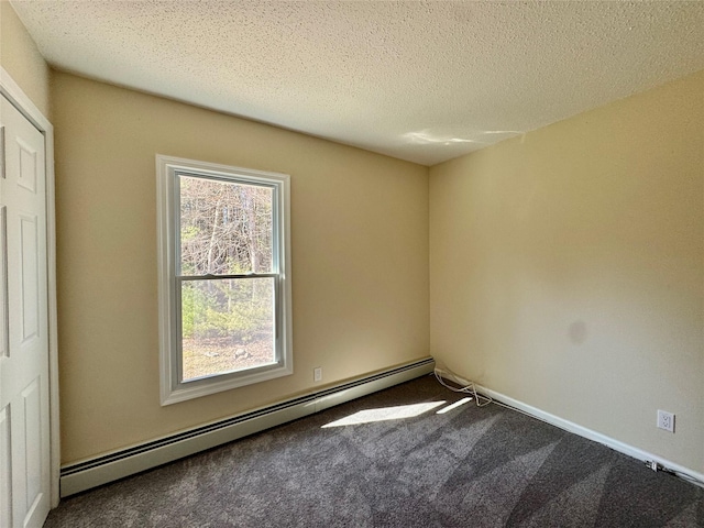 empty room with a baseboard radiator, carpet flooring, and a textured ceiling