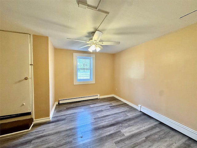 spare room featuring ceiling fan, wood finished floors, and a baseboard radiator