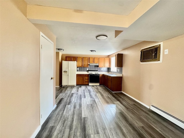 kitchen with light countertops, white appliances, dark wood-type flooring, a baseboard radiator, and a wall mounted AC