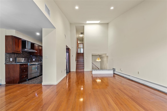 120-06 Riviera Ct Unit 17B, College Point, NY 11356 - unfurnished living room with light wood finished floors, stairway, recessed lighting, a baseboard radiator, and baseboards