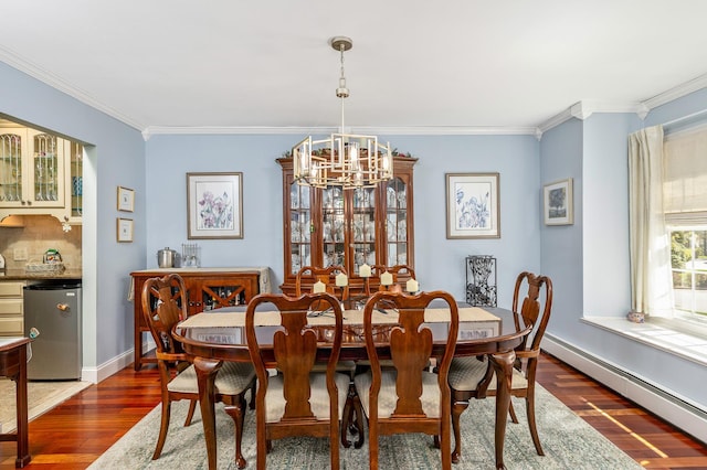 dining room with crown molding, dark wood finished floors, a notable chandelier, and baseboard heating