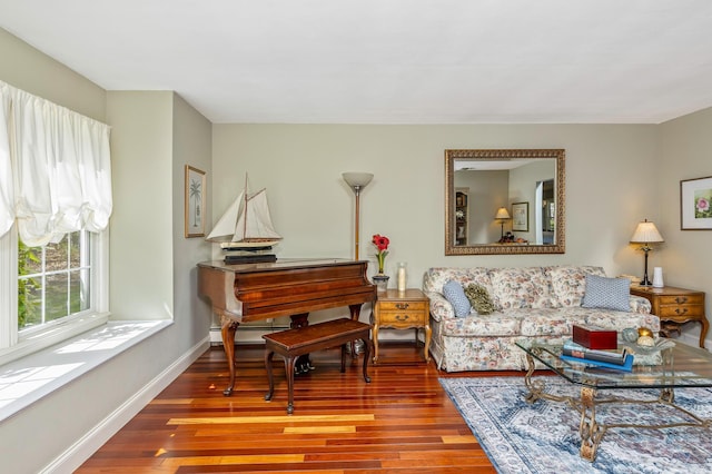 living room featuring baseboards, baseboard heating, and wood finished floors