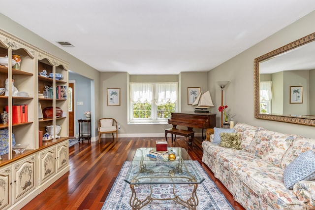 living area featuring baseboards, wood finished floors, and visible vents