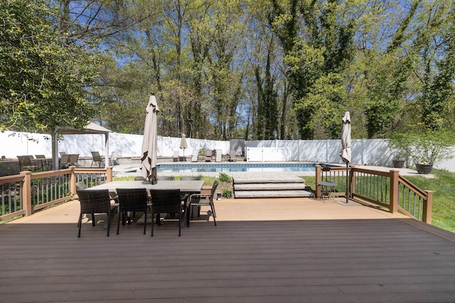 wooden terrace featuring a fenced backyard, a fenced in pool, and outdoor dining area