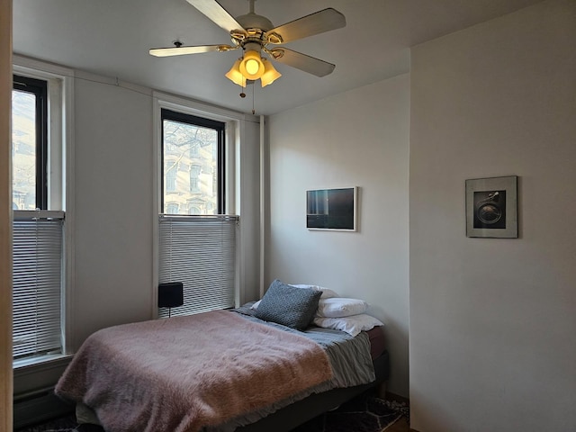 bedroom with a ceiling fan and multiple windows