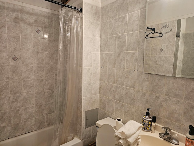 bathroom with toilet, a sink, and shower / tub combo with curtain