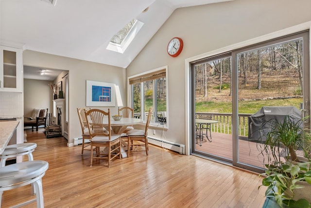 sunroom featuring a baseboard heating unit and a skylight