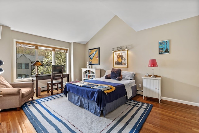 bedroom with lofted ceiling, baseboard heating, wood finished floors, and baseboards
