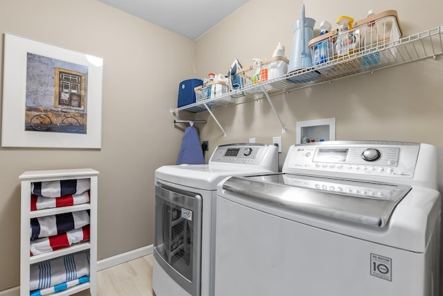 laundry room featuring baseboards, separate washer and dryer, laundry area, and light wood-style flooring